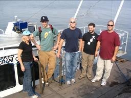 Keri Horbuckle and researchers pose for a photo next to a boat