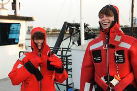 Two people dressed in rain gear on a boat