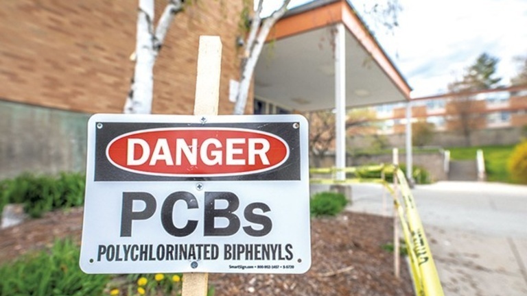 A PCB danger sign in front of Burlington High School